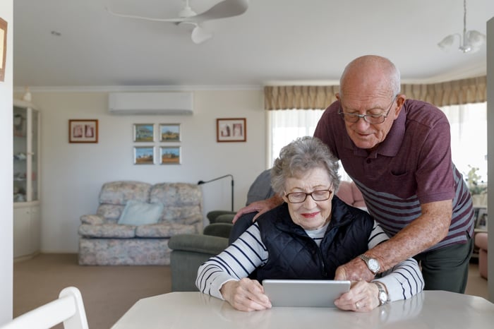 Two people at a table looking at a tablet.